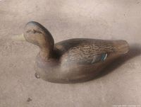profile view of carved wooden duck decoy, full body visible