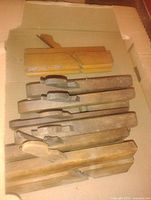 stack of eight wooden molding planes in box