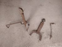 Four-piece antique cast iron andiron set laid on floor