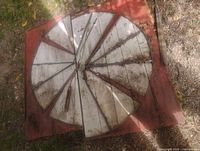 Overhead view of full circular barn wood ornament showing radial planks, metal center, overall wear