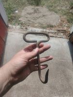 Full view of iron hay hook held in hand