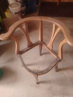 Top view of wooden Victorian corner chair frame showing curved crest rail and missing seat