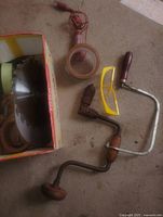 Brace drills, safety glasses, packing tape on floor next to box