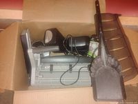 Box containing printer, speakers, cords and ash shovel