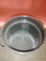 Top view showing perforated interior and enamel speckle finish