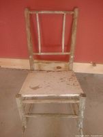 Front view of antique wooden spindle chair showing overall form and wear