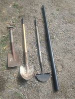 All four items laid on ground: square shovel, round-point shovel, half-moon edger, black PVC pipe