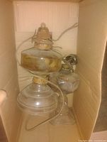Both glass oil lamps inside box showing overall shape and wiring