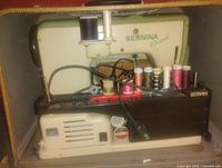 Bernina Record sewing machine with thread spools and cords in base