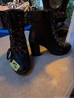 Front view of the pair of black lace-up ankle boots showing uppers, laces and heels