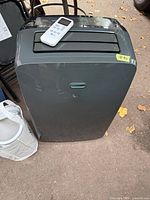 Front view of LG portable air conditioner with remote on top