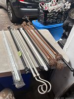 Group of curtain rods with various finial styles and finishes on table