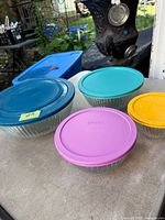 Set of four ribbed glass bowls with lids shown together