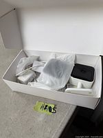 Open box showing two white Teckin cameras with mounts and cables in packaging