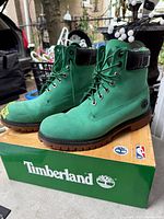 Full view of both green Timberland Celtics boots on box