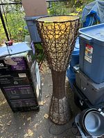 Full view of wicker floor lamp standing outdoors