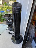 Full view of black Westinghouse tower heater on round base with power cord