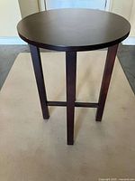 Full view of round accent table showing top, legs and stretcher