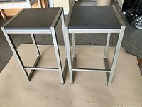 Two matching backless metal bar stools front angle