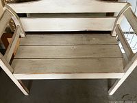 Front angled view of bench showing slatted seat and arms