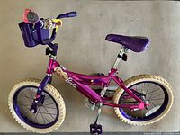 Full left-side view of Barbie bike showing frame, tires, basket, decals, seat and pedals