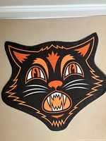 Full view of cat-shaped doormat showing design and colors