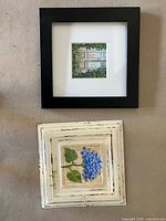 Black framed garden doorway print and white distressed frame hydrangea art displayed on floor