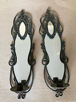 pair of dark green mirror candle sconces front view