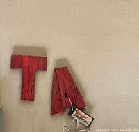 Red wooden letters A and T on wall