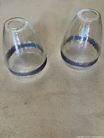 Both glass shades upside down showing shape, metal bands, and condition