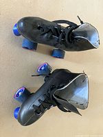 Top view of both black quad roller skates showing boots and wheels