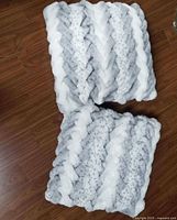 Front view of both faux fur pillows showing braided chevron pattern