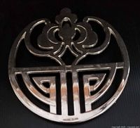 Front view of silver-plated trivet showing entire geometric design