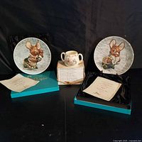 Overall lot showing two Pendelfin plates in boxes, Bunnykins mug, and stack of Beatrix Potter books