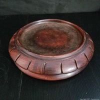 Top view showing circular mahogany coaster surface and carved rim