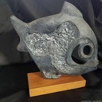 Front view of gray modernist fish sculpture on wood base