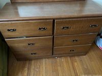Front view of six-drawer oak-finish dresser showing metal bail pulls and wear