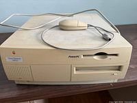 Front view of Apple Power Macintosh 7200/120 with mouse resting on top