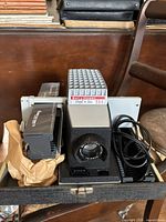 Projector, slide tray, power cord and case interior visible