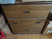 Front view of dresser showing all three drawers and metal pulls