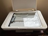 Top view of Canon PIXMA printer with open scanner lid showing glass platen and dirty edges
