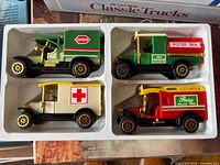 Four die-cast vintage delivery truck replicas in white plastic insert inside Classic Trucks box
