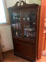 Front view of full china cabinet showing glass doors, interior shelves, drawers and lower cabinet