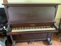 Full front view of Dominion upright piano showing keys, pedals and cabinet