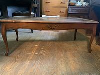 Full view of French Provincial coffee table showing top, legs, drawer front and finish condition