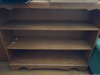 Light brown oak-finish wood veneer bookcase with three shelves, front view