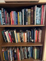 Three-shelf bookcase filled with assorted hardcover and paperback non-fiction books