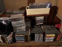 Overview of stacked CDs, cassette tapes, cube racks, and cardboard boxes