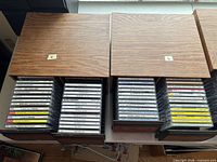 Top view of two wood-grain laminate CD drawer boxes numbered 5 and 6; drawers open showing rows of CDs in jewel cases