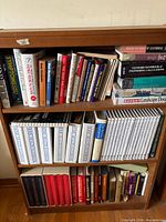 Bookcase with three shelves showing assorted health, engineering and reference books including Home Health Handbook series and Standard Handbook of Engineering Calculations